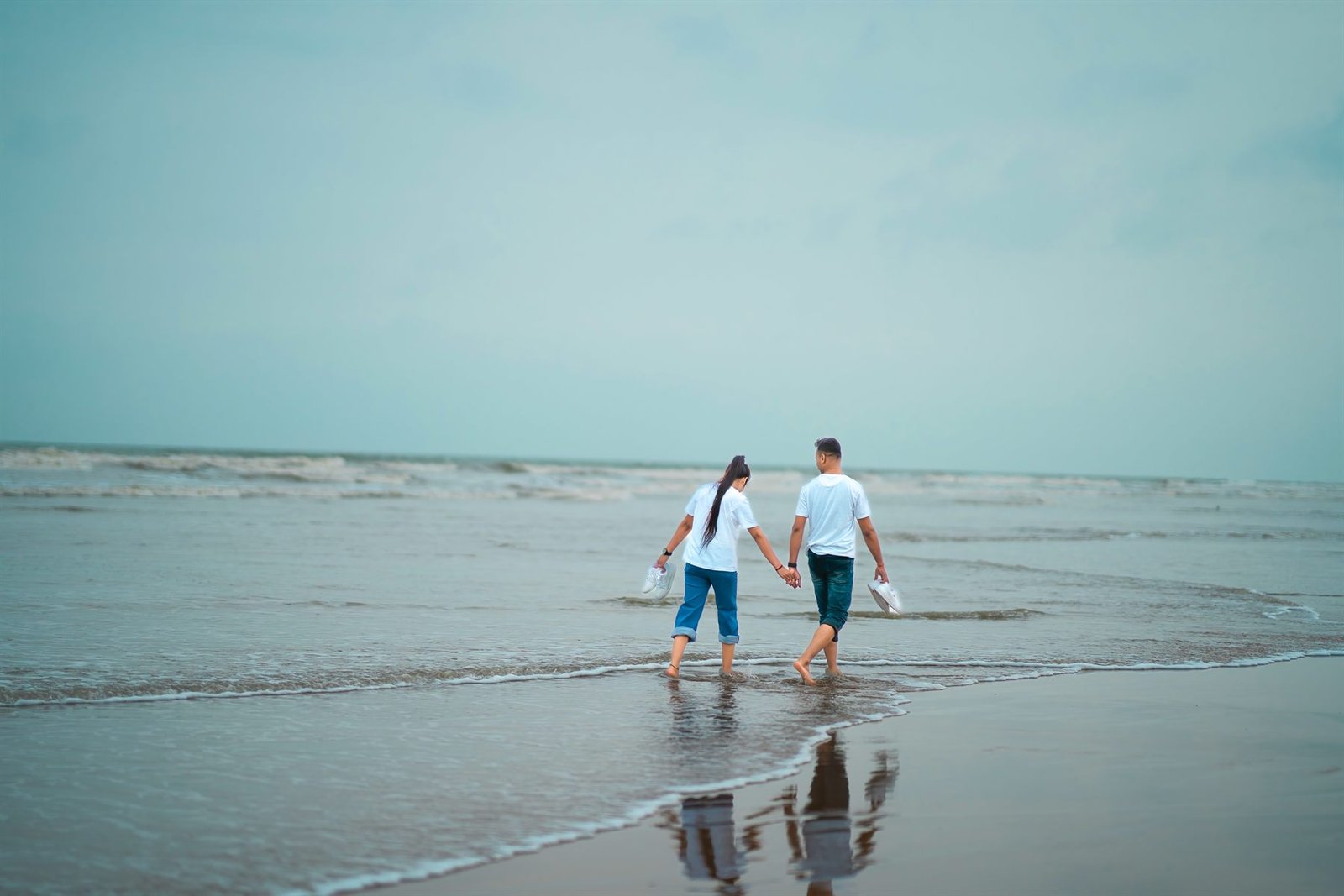 Couple walking beside the sea